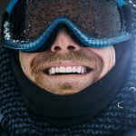 Mann bereit für den Wintersport mit Skibrille und Winterjacke