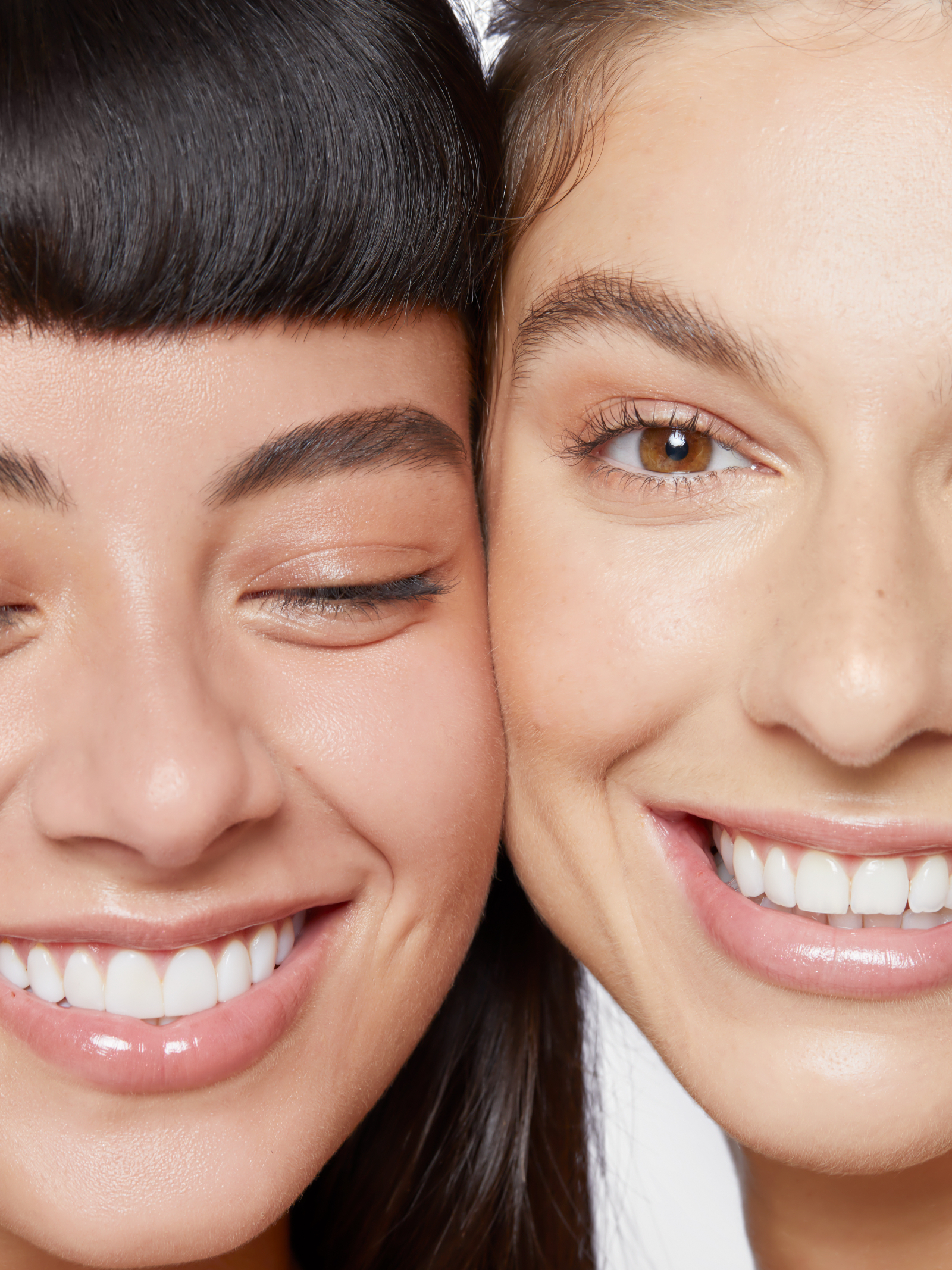 2 females with faces side by side laughing