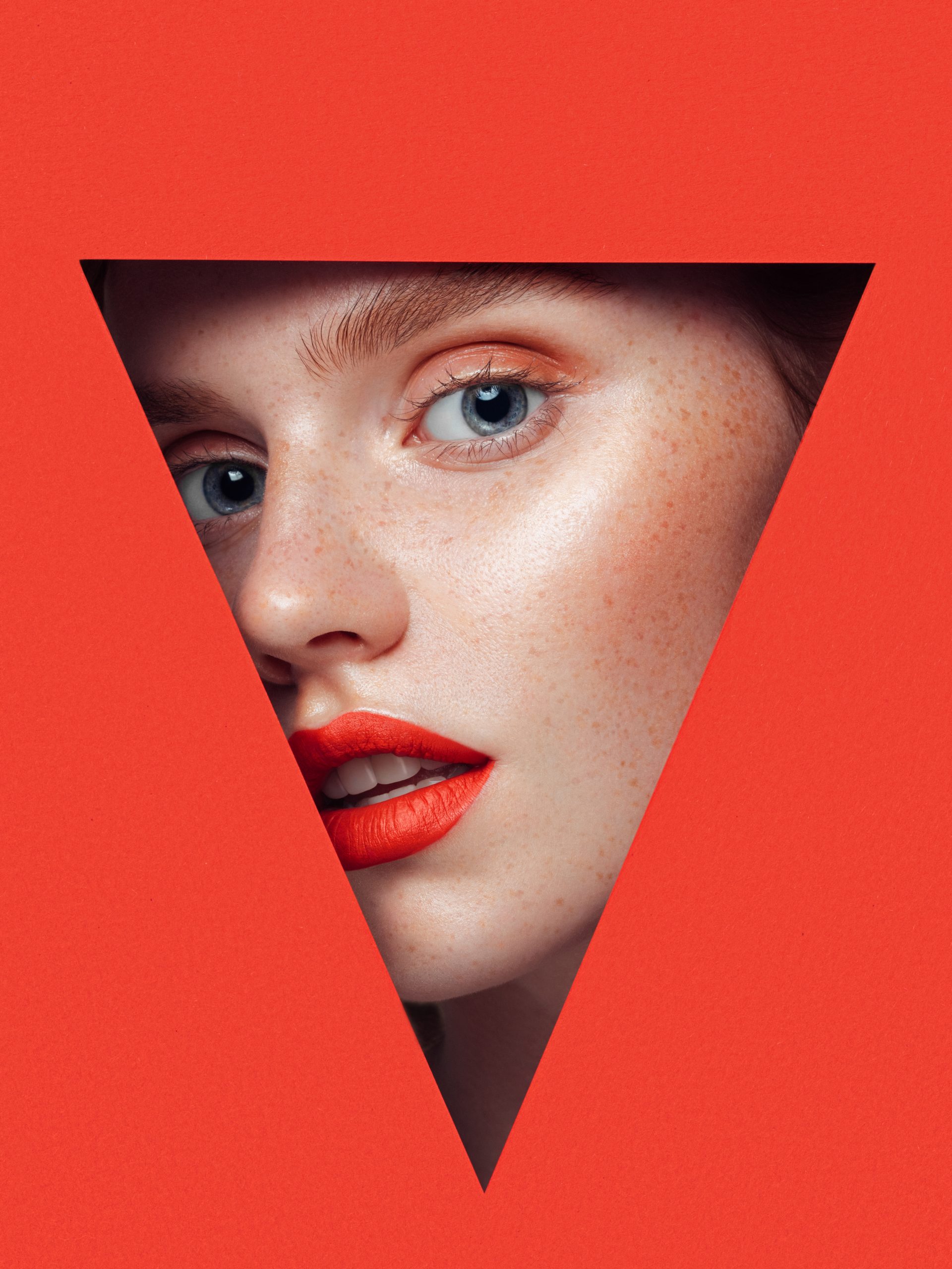 Beautiful woman looking through a triangular hole. Beautiful woman looking through a triangular hole.