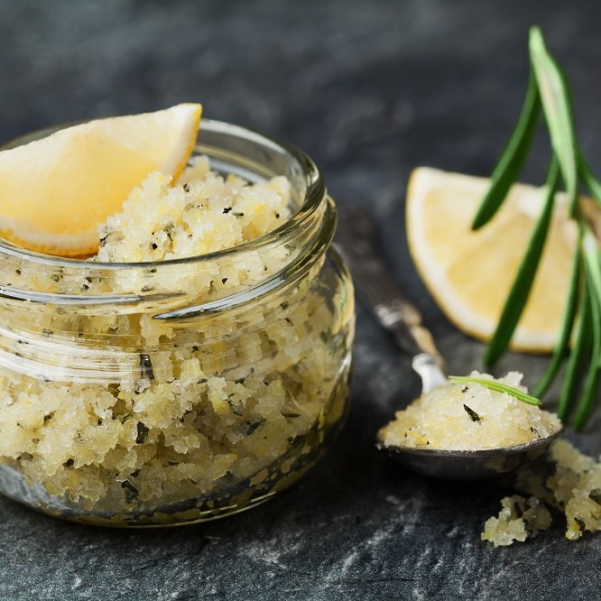 Körperpeeling mit Seesalz, Zitrone, Rosmarin und Olivenöl in einem Glas