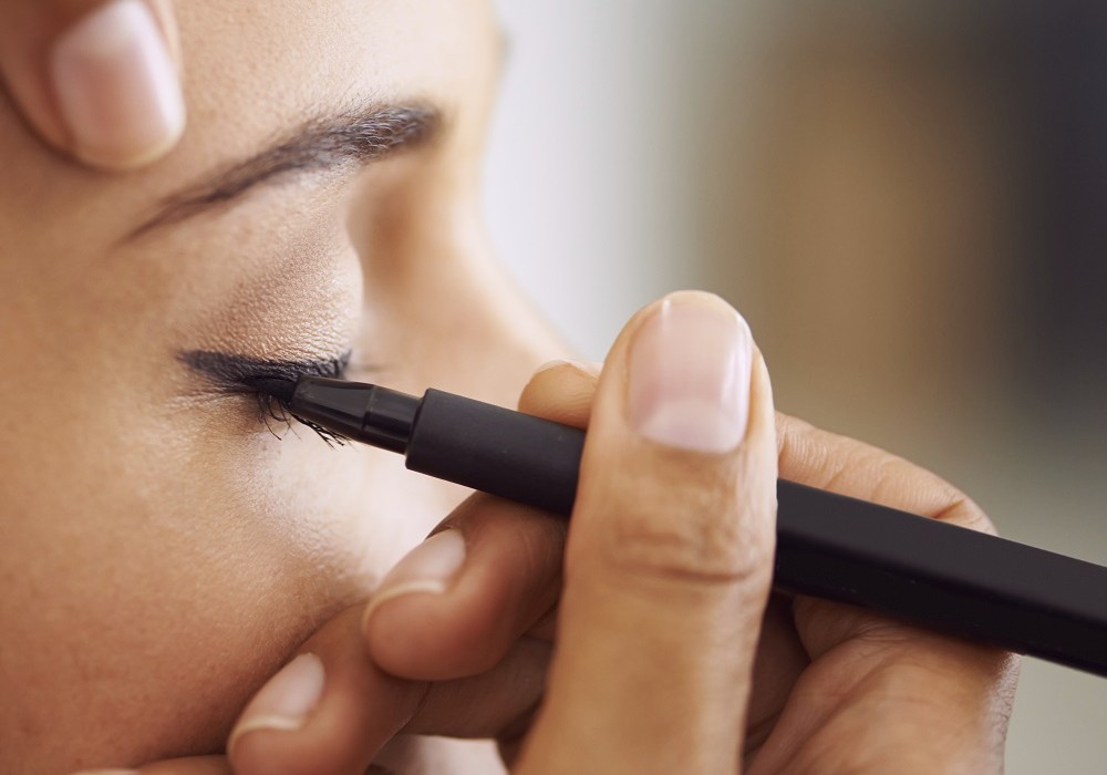 Closeup of a young woman getting liner applied to her eyes