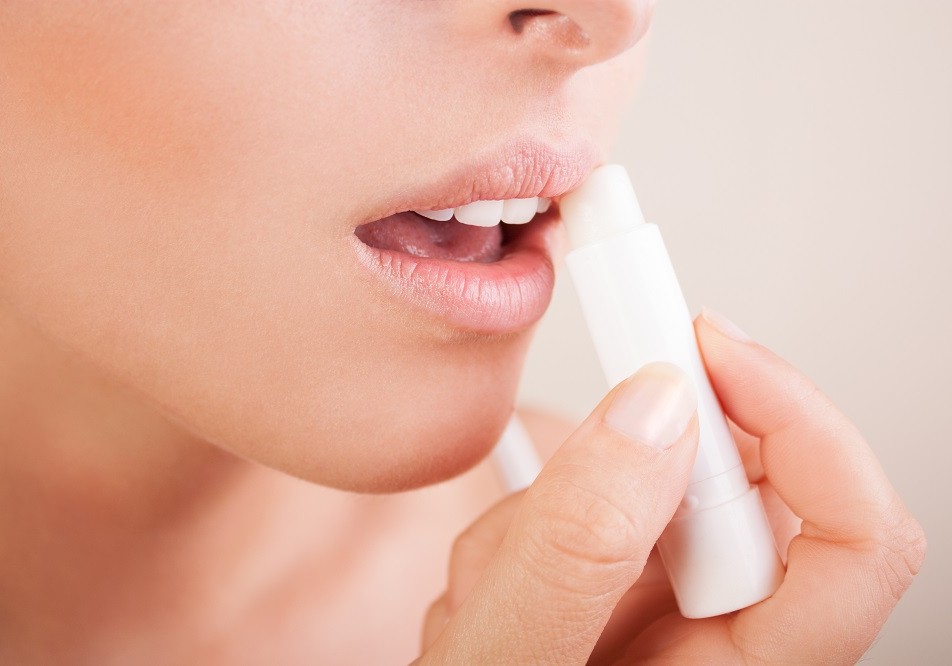 woman applying balsam on lips