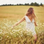 Junge Frau im Sommer auf einer Blumenwiese